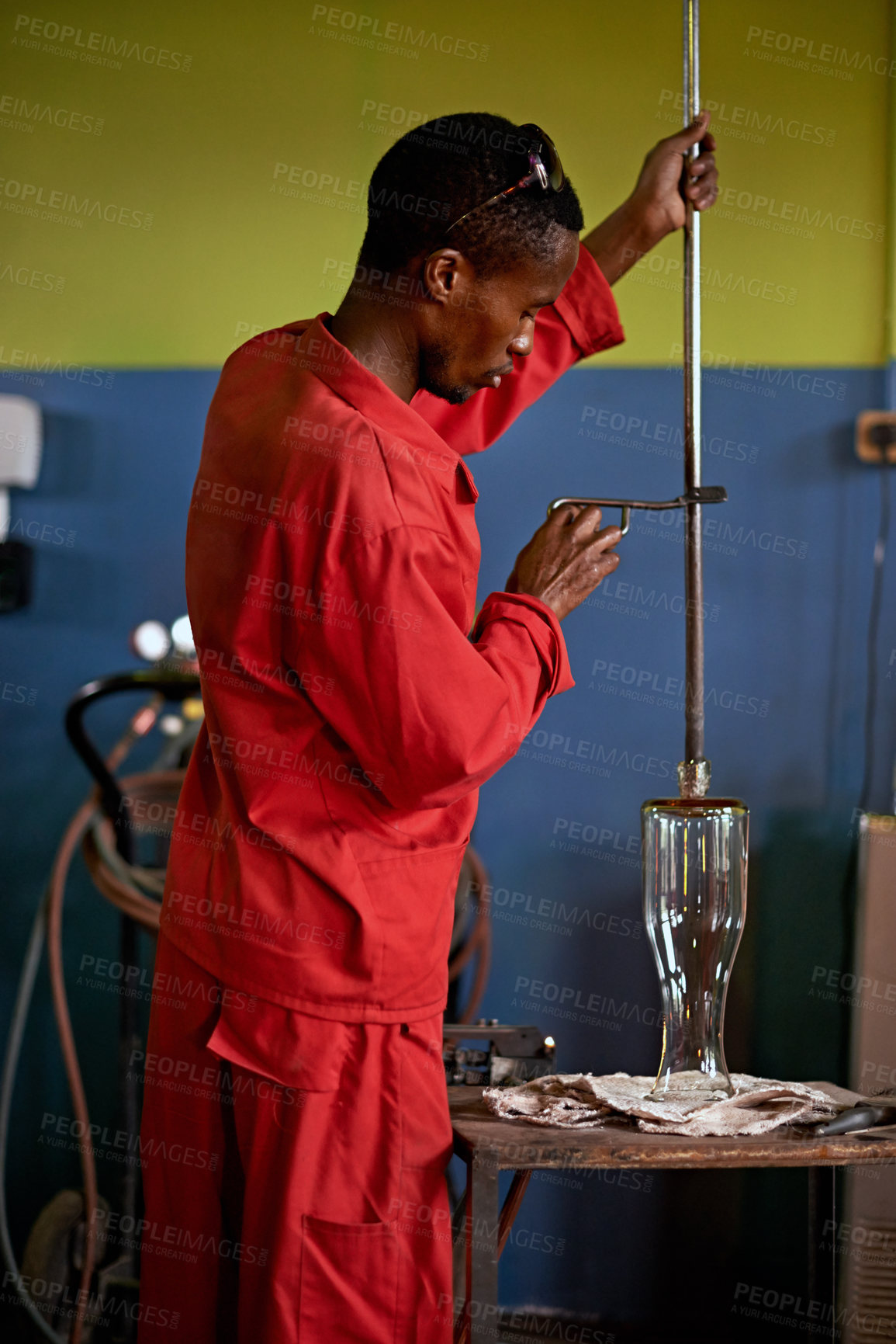 Buy stock photo Glassblowing, creative and man with tools, factory and busy for manufacturing of glass and industry. Production, working and person in uniform for craft, glassmakers and art for design of product