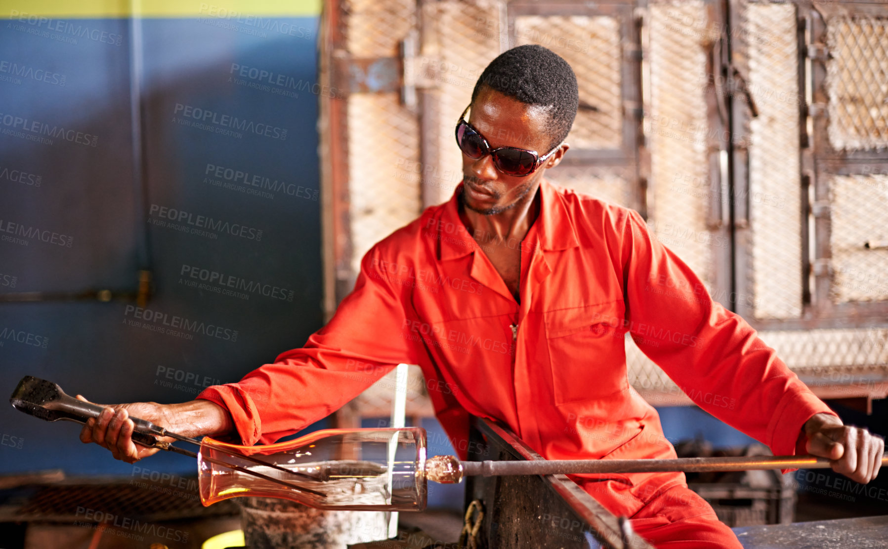Buy stock photo Glass, blowing and black man in workshop with safety, small business or handmade craft form. Art, product shape and glassblower in factory for sustainable process, bottle design and sculpture tools