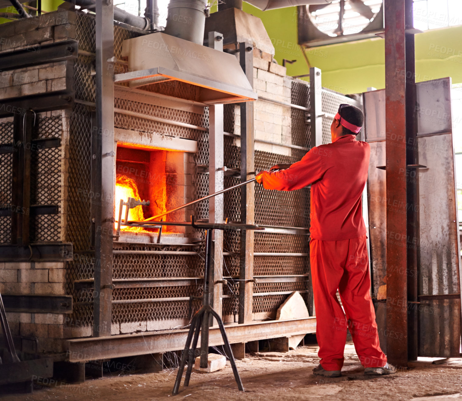 Buy stock photo Glass factory, man and fire in furnace for production process, manufacturing and back in industry. Glassware, tools and craft for art with worker for recycling, melt and African person glassblowing