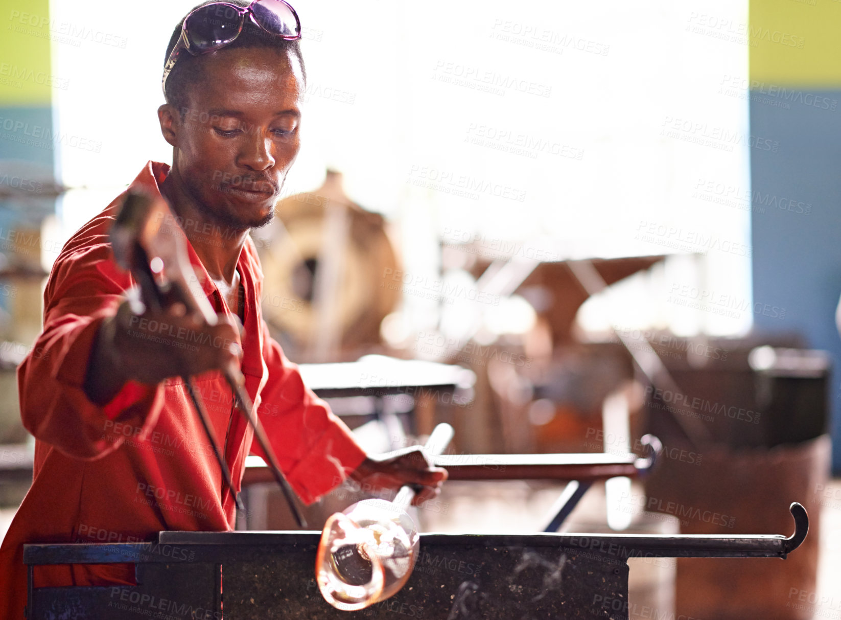 Buy stock photo Glass blowing, artist and black man in workshop for creative small business, talent and handmade process. Art, product shape and glassblower in factory for sustainable project, design or craft tools
