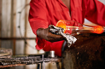 Buy stock photo Glass, glowing and wipe with hands of person in forge or foundry for manufacturing or production. Heat, process and rag with professional glassblower in factory, plant or workshop to finish product