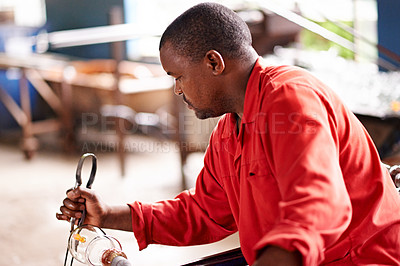 Buy stock photo Glassblowing, skill and tongs with black man artisan in forge or foundry to craft or shape product. Artistic, creative and design with glassblower in factory, plant or workshop for manufacturing