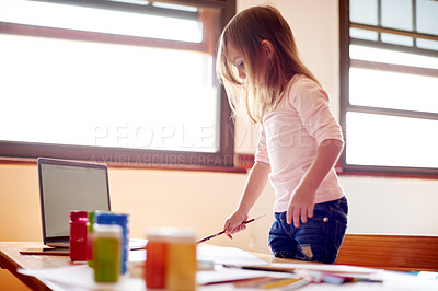 Buy stock photo Child, laptop and painting in home for creativity, online tutorial or learning with colors. Girl, tech screen mockup or brush in living room for artwork, creative outlet or streaming lesson for ideas