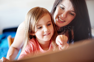 Buy stock photo Laptop, elearning and pointing with mother with kid for online education app, kindergarten student or creative phonic skills. Child development, teaching and search with woman and girl in family home