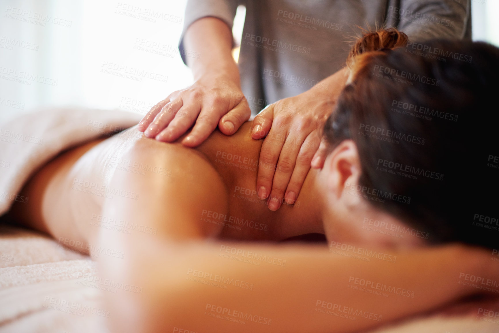 Buy stock photo Woman, relax and masseuse with massage at beauty spa for physical therapy or body treatment at resort. Female person, lying and relaxation on bed at luxury salon for shoulder rub or stress relief