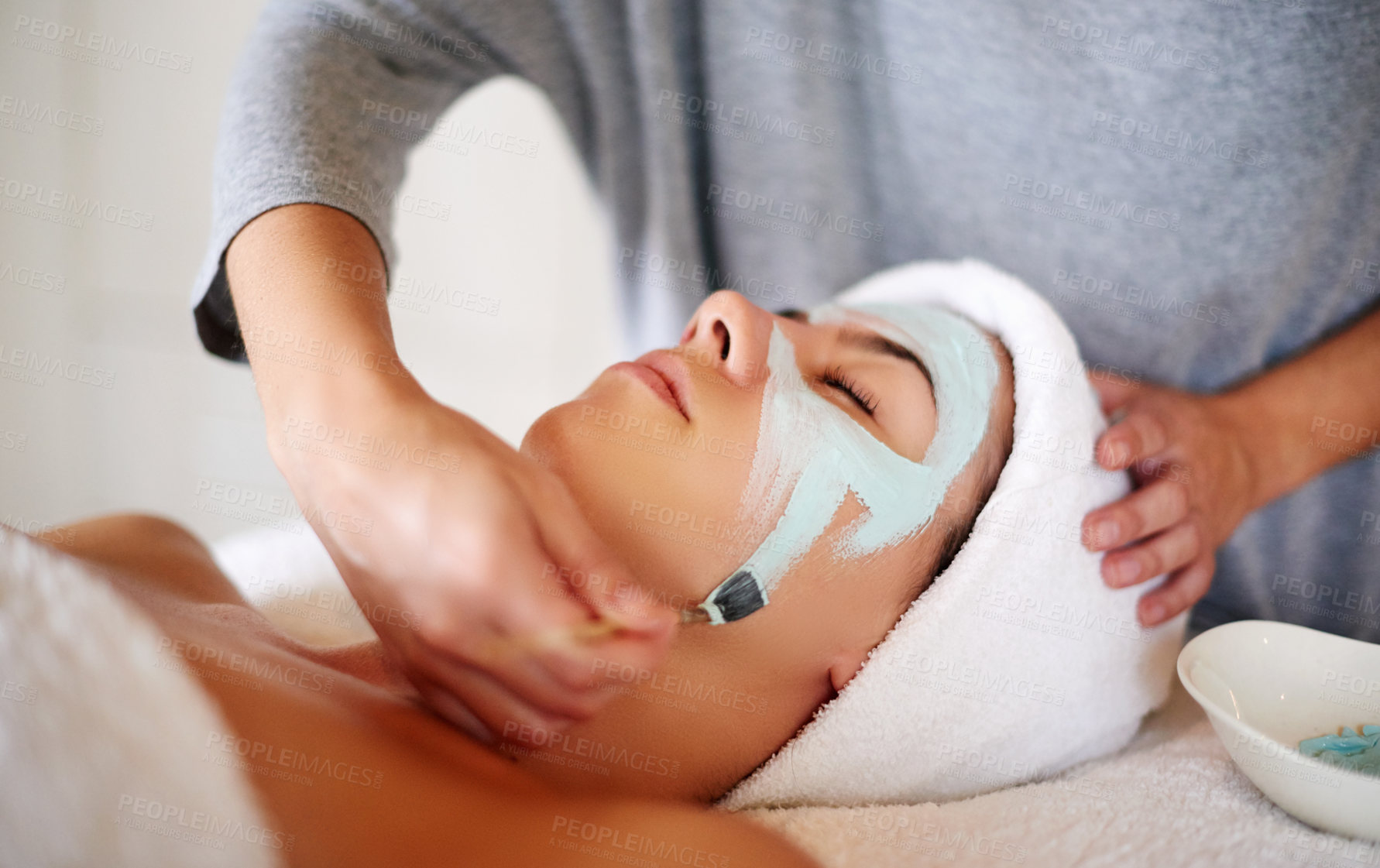 Buy stock photo Skincare, hands and client with facial at beauty salon for skin exfoliation, dermatology and acne treatment. Beautician, woman and clay mask at spa for face cleansing, healthy glow and luxury pamper
