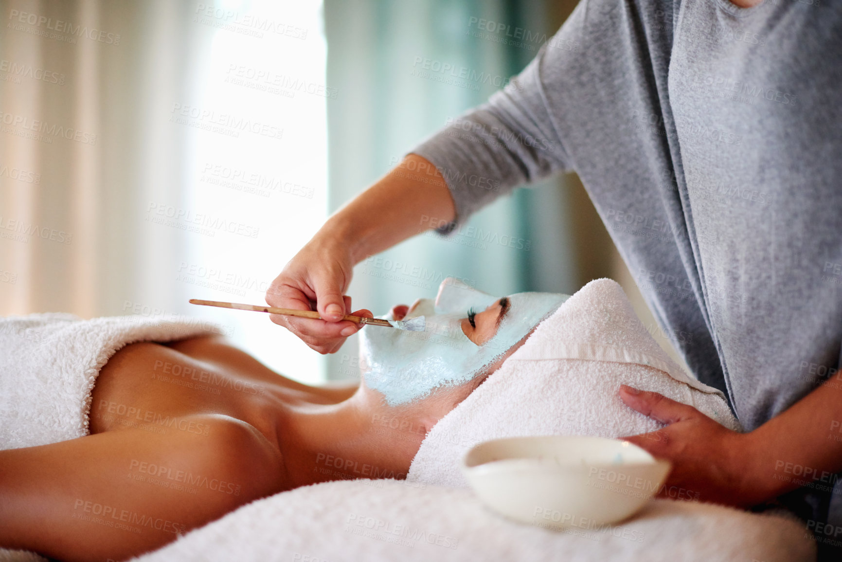 Buy stock photo Beauty, hands and client with mask at spa for facial treatment, deep cleaning or skin exfoliation. Skincare, beautician or woman with clay application for hydration or natural glow at wellness salon