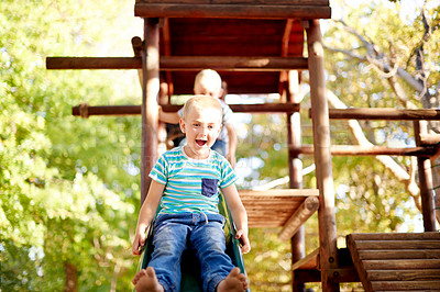 Buy stock photo Excited, playing and portrait of children on slide in park for physical skills, confidence or fun. Exploring, nature and boy kid son playground equipment for adventure, hobby or cognitive development