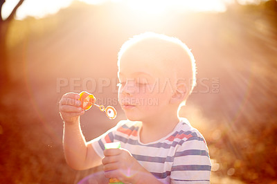 Buy stock photo Bubbles, sunset and child in park with fun, adventure play and outdoor development for kids in nature. Relax, weekend and boy in garden playground with soap wand, childhood games and playful activity
