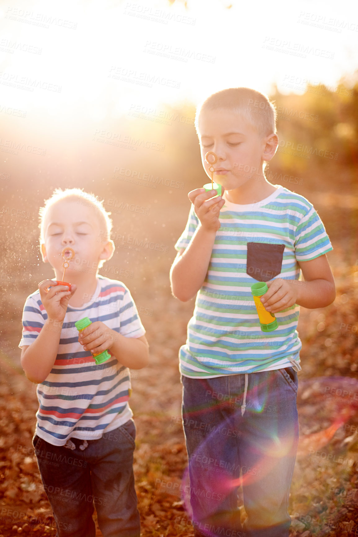 Buy stock photo Happy, blowing bubbles and children for playing, childhood and bonding together in nature. Family, sunlight and young brothers outdoors with soap, toys and activity for fun, adventure or game in park