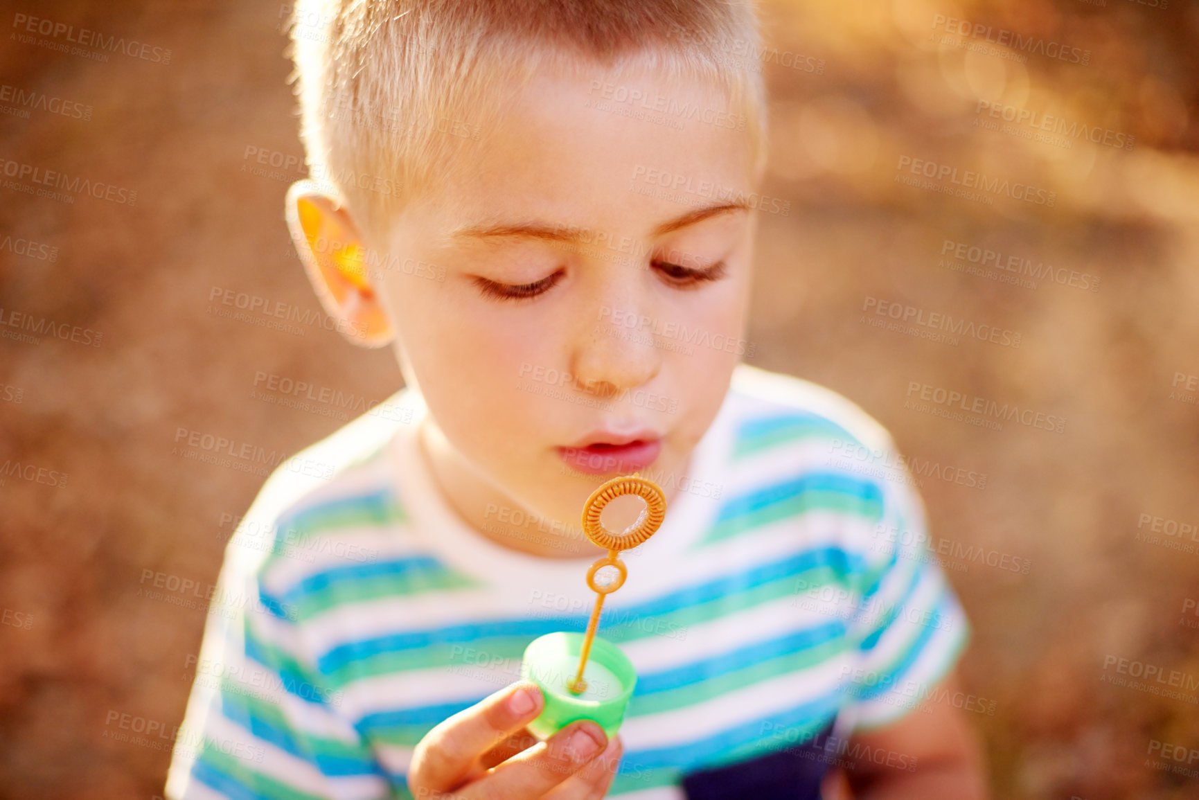Buy stock photo Bubbles, blowing and kid in park with play, sunset adventure or outdoor development for children in nature. Relax, weekend and boy in garden playground with soap wand, childhood games or fun activity