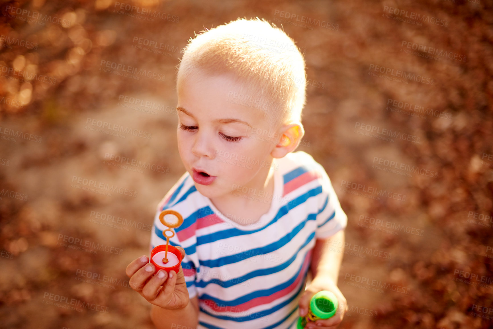 Buy stock photo Bubbles, blowing and child in field with fun, sunset adventure and outdoor development for kids in park. Relax, weekend and boy in garden playground with soap wand, childhood games and play activity