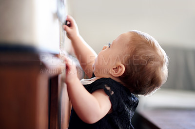Buy stock photo Cabinet, climbing and development with baby girl in home for curiosity, discovery or growth. Balance, coordination and drawer with adorable infant child in nursery of apartment to explore or discover