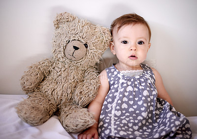 Buy stock photo Baby, girl and bed with teddy bear for playful childhood, youth or growth in development at home. Little kid, infant or adorable child with cute dress or big stuffy in bedroom for nursery at house
