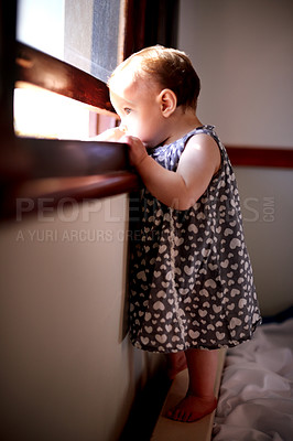 Buy stock photo Curious, growth and window with baby girl in home for child development, imagination or wonder. Balance, cute and dress with inquisitive infant in bedroom of apartment to discover and explore