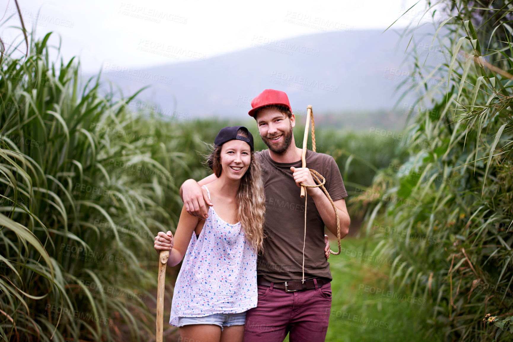 Buy stock photo Happy couple, portrait and hiking outdoor with stick for travel, adventure or embrace for love in countryside. Man, woman and trekking in nature together for tourism, vacation or journey in Australia