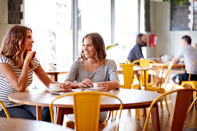 Buy stock photo Women, smile and gossip in cafe for social meeting, connection and bonding at lunch date. Cappuccino, brunch and twin sisters in coffee shop together for morning drinks, chat and restaurant reunion
