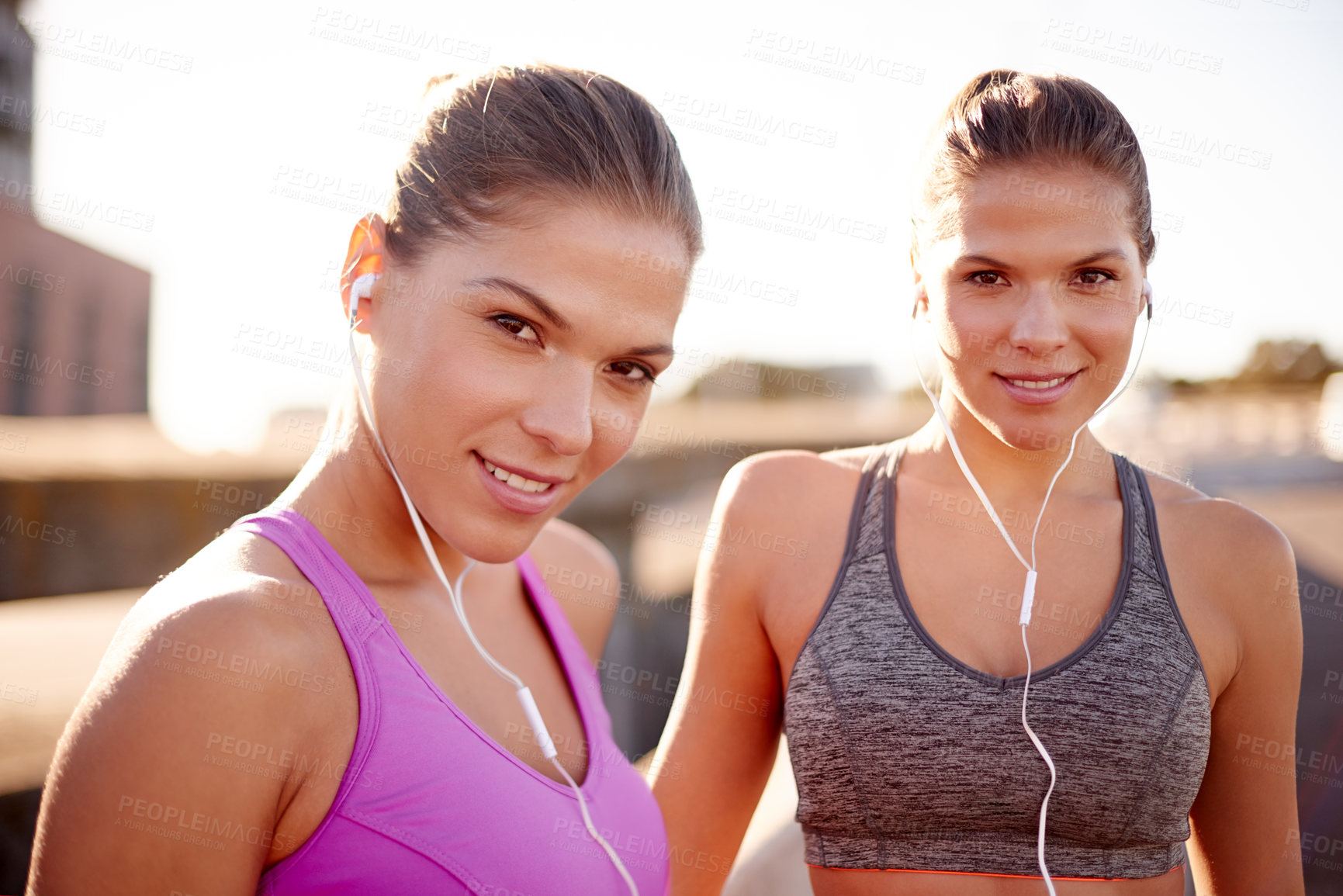 Buy stock photo Women, exercise and together with earphones in city for music, training and sisters in summer. People, runner and twins with streaming, subscription and portrait for workout on urban bridge in Italy