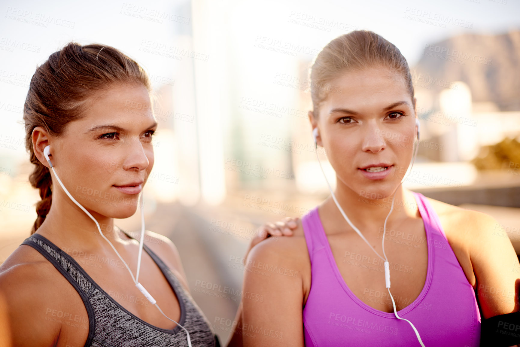Buy stock photo Earphones, fitness and portrait of twins in city for running with marathon training with music. Sisters, sports and women with audio tech for cardio workout or exercise on bridge in town together.