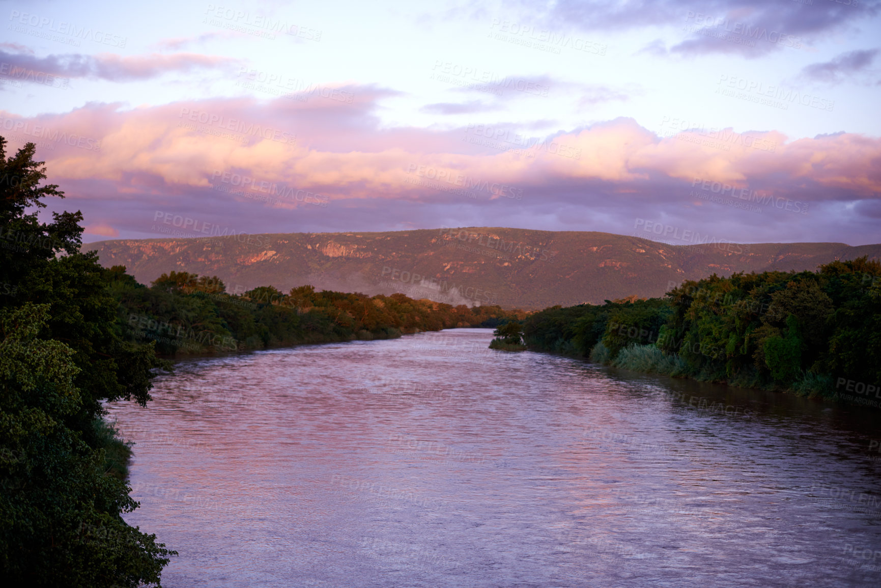Buy stock photo Forest, lake and mountain outdoor at sunset for travel, holiday or vacation location with sky. Woods, river and water with landscape environment, clouds and ecosystem with trees for tourism in Chile