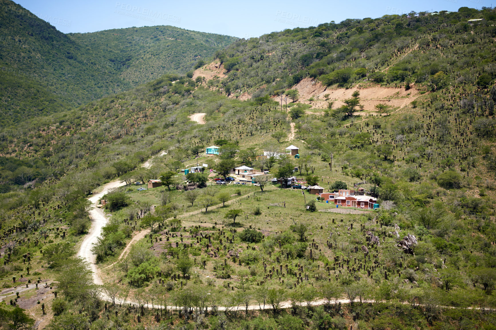 Buy stock photo Houses, resort or village on hill in nature for travel, sustainability and rural community in valley. Buildings, mountain and drone landscape of eco park, green commune or farm town environment
