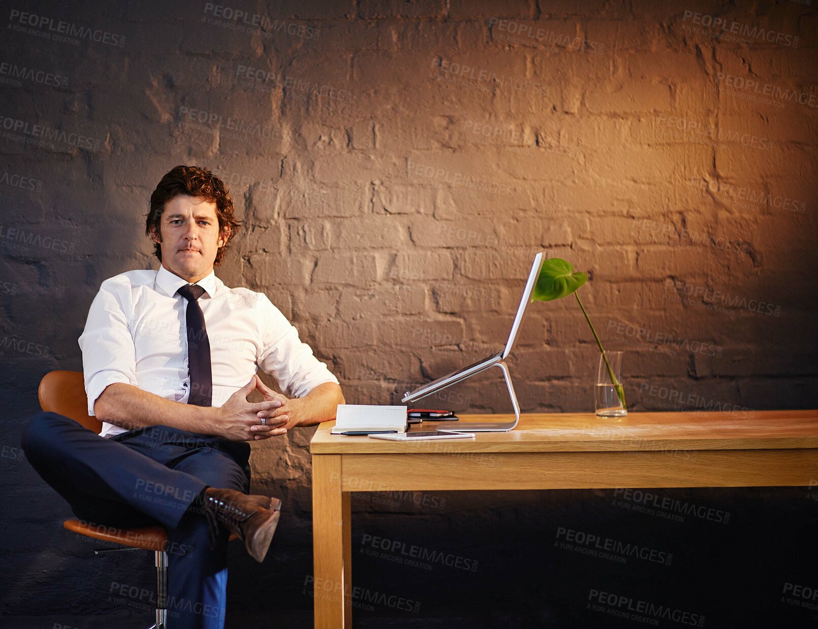 Buy stock photo Desk, investigation and portrait of serious detective in office at night to work on criminal report. Brick wall, laptop and notebook with mature investigator in agency for evidence, or justice