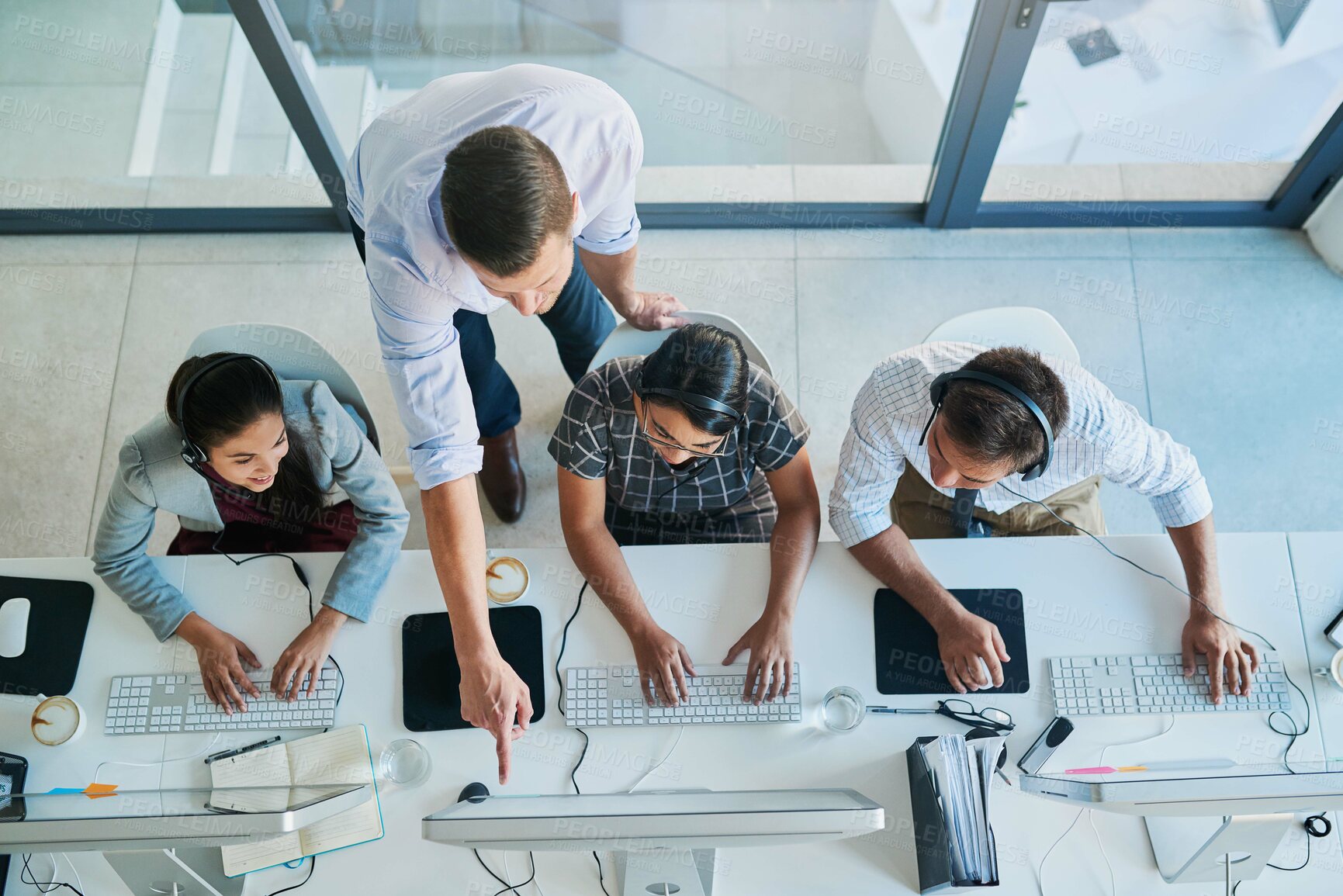 Buy stock photo High angle shot of a man assisting his colleagues in a call center