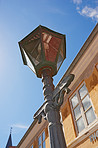City, closeup or pole with outdoor lantern or lamp for urban housing, retro style or town development. Project, low angle or outside of design for vintage architecture, bright light or location in UK