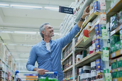 Buy stock photo Happy, shopping and man in supermarket with shelf for food, grocery and products at convenience store. Retail, consumer and person with trolley in aisle for choice, options and discount purchase