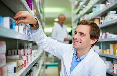 Buy stock photo Man, pharmacy and stock shelves at store, employee and confident chemist for medicine. Male person, dispensary and proud of medication treatment at apothecary, expert service and check inventory