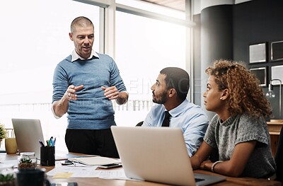 Buy stock photo Businessman, laptop and coaching with team in presentation for company mission or meeting at office. Young group of employees listening to speaker on computer for training or project at workplace