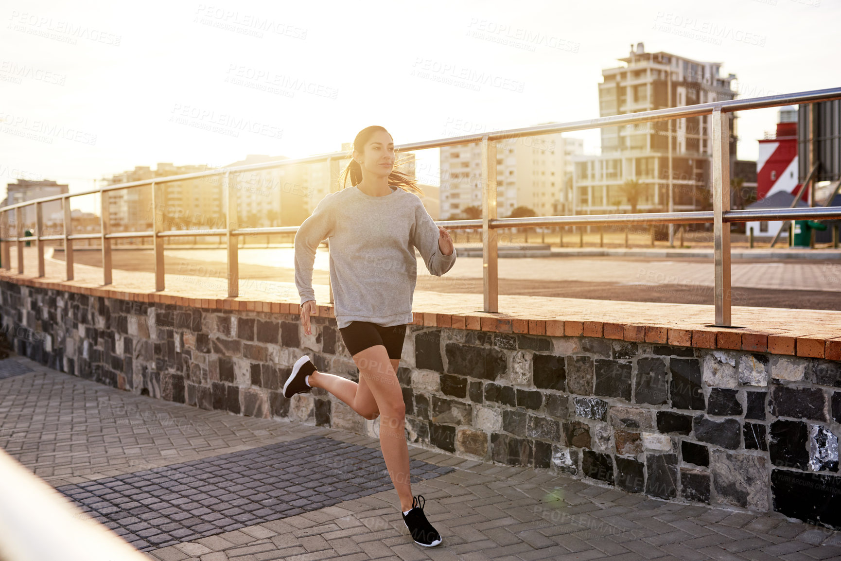 Buy stock photo Fitness, sports and woman running in city for healthy body, wellness or jog to lose weight at sunset. Cardio, outdoor and athlete training, exercise or endurance workout with energy for marathon race
