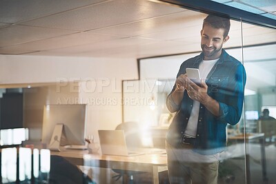 Buy stock photo Man, phone and texting in office, night and overtime with update, reading and contact with app at company. Person, smartphone and check notification with smile, startup or web chat at creative agency