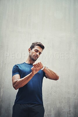 Buy stock photo Man, smart watch or runner by wall for workout, exercise or training in outdoor sports or healthy fitness. Smile, grey background or athlete checking time for cardio, wellness or running performance