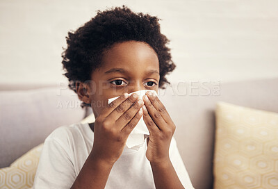 Buy stock photo Tissue, sick and child blowing nose in home for recovering of flu, allergies or cold in living room. Illness, relax and boy kid sneezing for medical virus or sinusitis on sofa for healing at house.