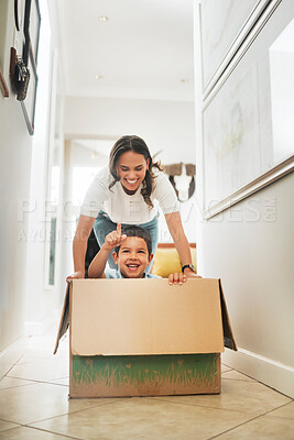 Buy stock photo Box, moving house and mother pushing son for having fun or playing game in new home together. Cardboard, pointing and smile of woman parent with boy child in apartment for property investment