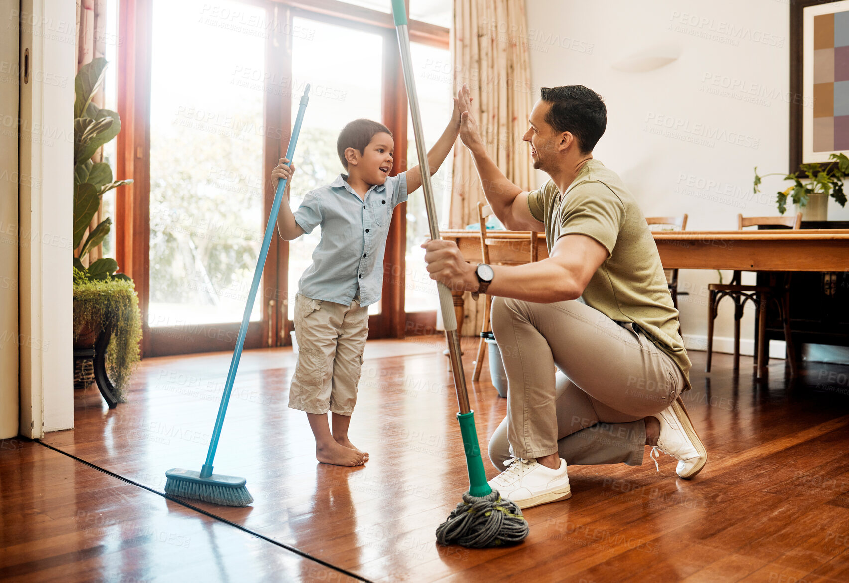 Buy stock photo Cleaning, high five or sweeping with father and son in dining room of home together for weekend chores. Motivation, success or teamwork of man parent and boy child in apartment with broom and mop