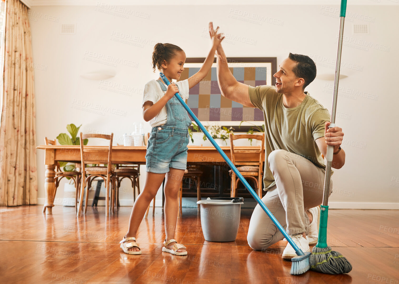 Buy stock photo Cleaning, dad and child in home, high five and celebration for complete chores, happy or kid with broom. Finished, man and sweeping with daughter in kitchen, success or smile for achievement in house