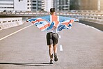 Winner, flag and fitness man running on the city road celebrates winning achievement in summer. Sports, training and competitive British male runner doing healthy exercise in celebration outside