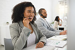 Young cheerful mixed race female call center agent answering calls while wearing a headset at work. Hispanic businesswoman with a curly afro talking on a call while working on a desktop computer at a desk in an office