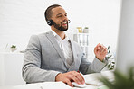 Young cheerful mixed race male call center agent answering calls while wearing a headset at work. Hispanic businessman talking on a call while working on a desktop computer at a desk in an office