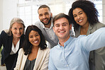 Group of cheerful diverse businesspeople taking a selfie together at work. Happy young caucasian businessman taking a photo with his content colleagues in an office. Coworkers bonding at work