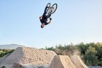 Bike, nature and outdoor sports while biking doing dangerous jump in air for fitness, exercise and training with athlete energy. Man cycling with bicycle at park for mountain bike freedom adventure