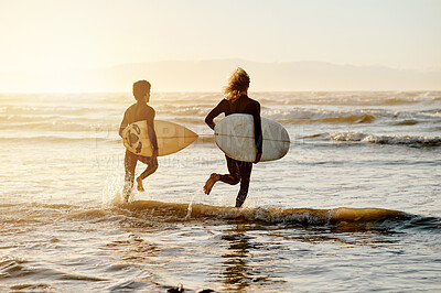 Buy stock photo Surfing, friends and running at sunset beach for waves, freedom and swim on travel from behind. Surfboard, surfer and guys at sea, ocean and excited adventure on holiday, summer and fun water sports
