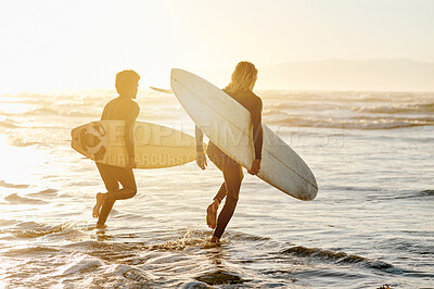 Buy stock photo Back view, men and surfing friends at running sunset beach for waves, freedom and swim. Silhouette of surfer guys with board at sea, sunshine and adventure on holiday, travel and summer water sports 