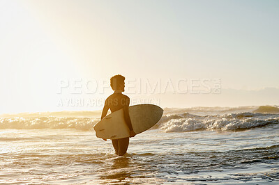 Buy stock photo Sunset, beach and man with a surfboard in the ocean for training while on holiday or vacation. Water sport, travel and male surfer practicing surfing in sea while on tropical weekend trip by twilight