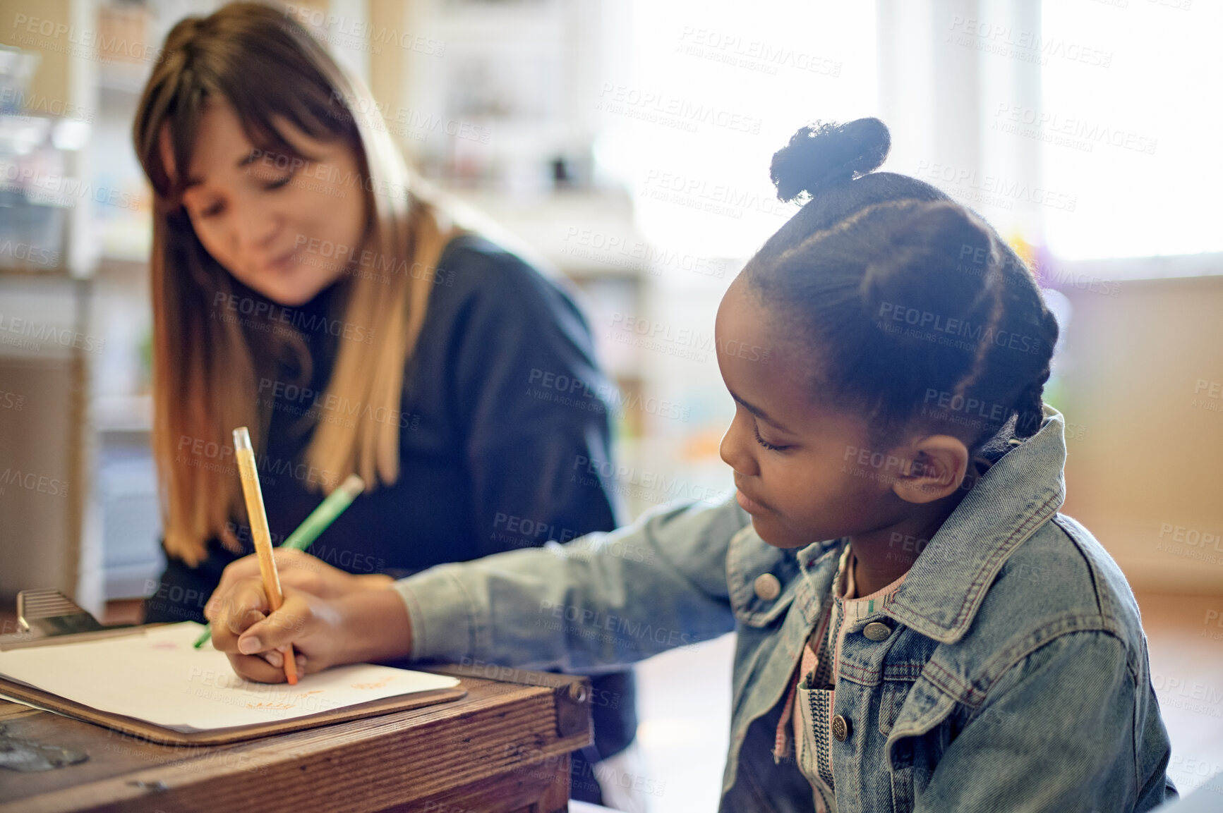 Buy stock photo Education, writing and teacher with a girl in a classroom for learning, studying and creativity. Help, homework and African student with a woman drawing in a book for support, teaching and lesson