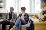 Psychology, sofa and couple talking to a therapist in her modern office at counseling clinic. Discussion, therapy session and interracial man and woman on couch speaking to relationship psychologist.