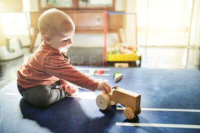Buy stock photo Baby boy, playing and tractor toys in home with morning sunshine for learning, development and skills. Young male kid, drive wood toy and infant child with games in house, apartment or living room