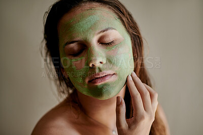 Buy stock photo Facial, skincare and woman using cosmetic product on her face for beauty, treatment and self care in a studio background. Detox, mask and female cleaning her skin for morning routine while she relax